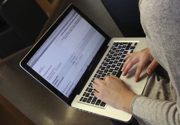 Person mit Laptop bestellt im Online-Katalog