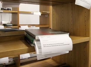Bücher liegen im Regal zur Abholung bereit