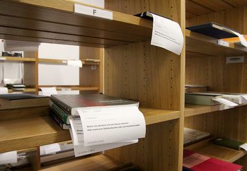 Bücher liegen im Regal zur Abholung bereit