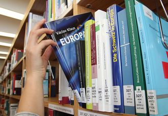 Person nimmt Buch aus dem Regal 