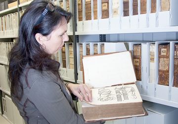 Mitarbeiterin schlägt eine Handschrift auf