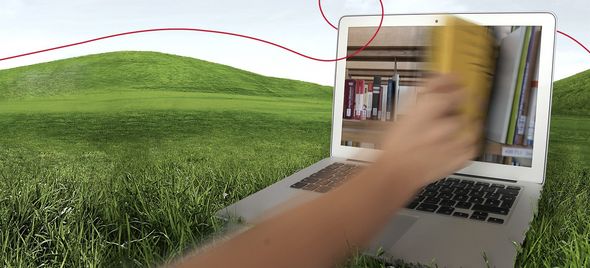 Eine Hand zieht ein Buch aus einem Laptopscreen