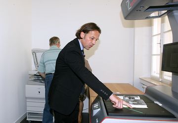 Person beim Bedienen des Auflichtscanners.