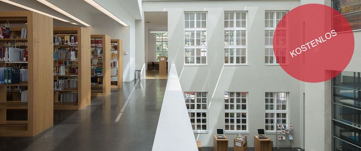 links Bucherregale, in der Mitte ein Gang, rechts große Fenster.